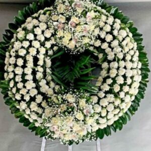 Στεφάνι κηδείας σε σχήμα ρόδας με δύο κατασκευές από τριαντάφυλλα και σιμπίντιουμ. Σταθερή τρίποδη βάση, δωρεάν αποστολή στην Αθήνα.